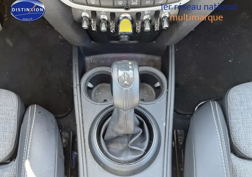 Gros plan sur la console centrale de la MINI Countryman hybride avec levier de boîte auto et porte-gobelets.