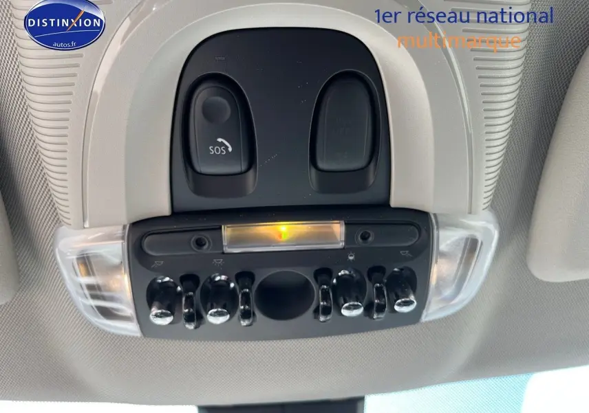 Vue en gros plan du plafonnier avec interrupteurs chromés et bouton SOS dans l'habitacle clair d'une MINI Countryman Moonwalk Grey.