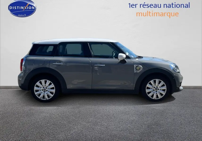 Profil droit d'une MINI Countryman Cooper SE Moonwalk Grey avec toit et rétroviseurs blancs, jantes 18 pouces design Pin Spoke.
