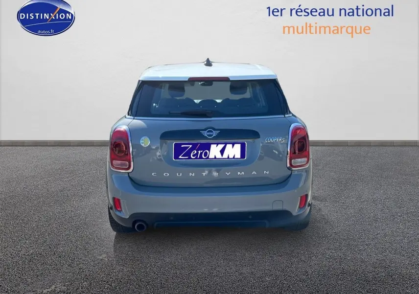 Vue arrière d'une MINI Countryman Cooper SE Moonwalk Grey avec toit blanc et feux LED, sur fond neutre.