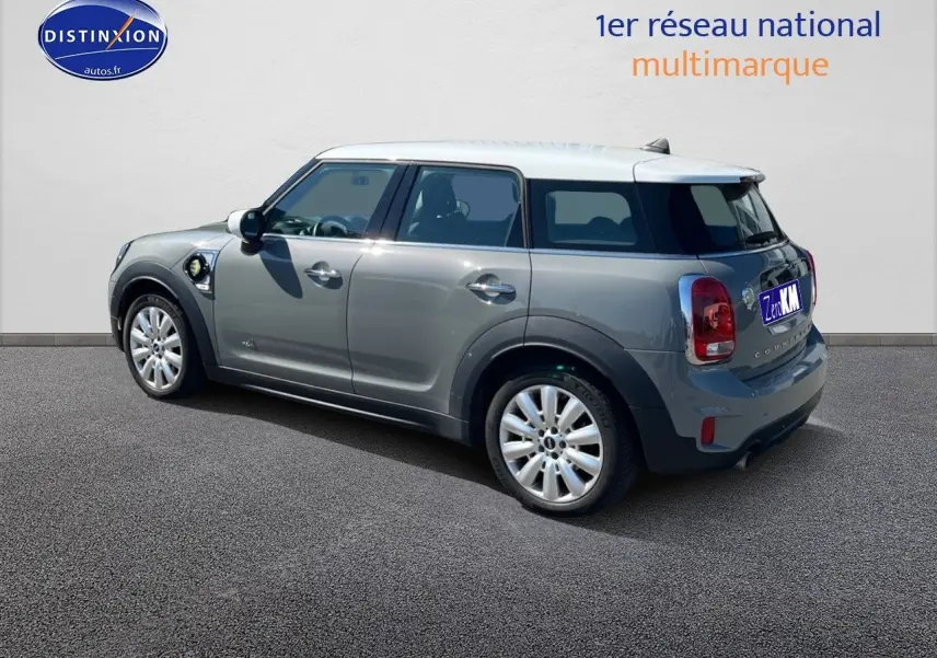 Vue 3/4 arrière droite d'une MINI Countryman hybride gris Moonwalk avec toit et rétroviseurs blancs et jantes alu 18 pouces.