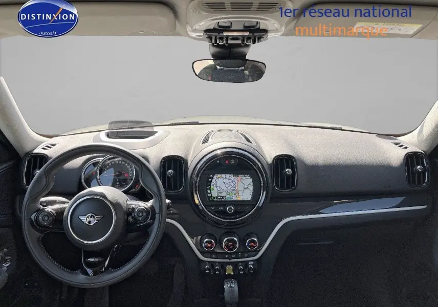 Vue frontale intérieure du tableau de bord noir du MINI Countryman Cooper SE avec écran GPS circulaire et volant multifonction.