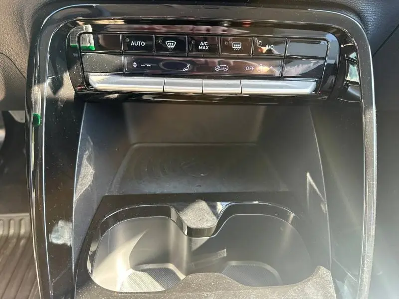 Détail de la console centrale noire du Citroën C3 2025, montrant les commandes de climatisation et un double porte-gobelets.