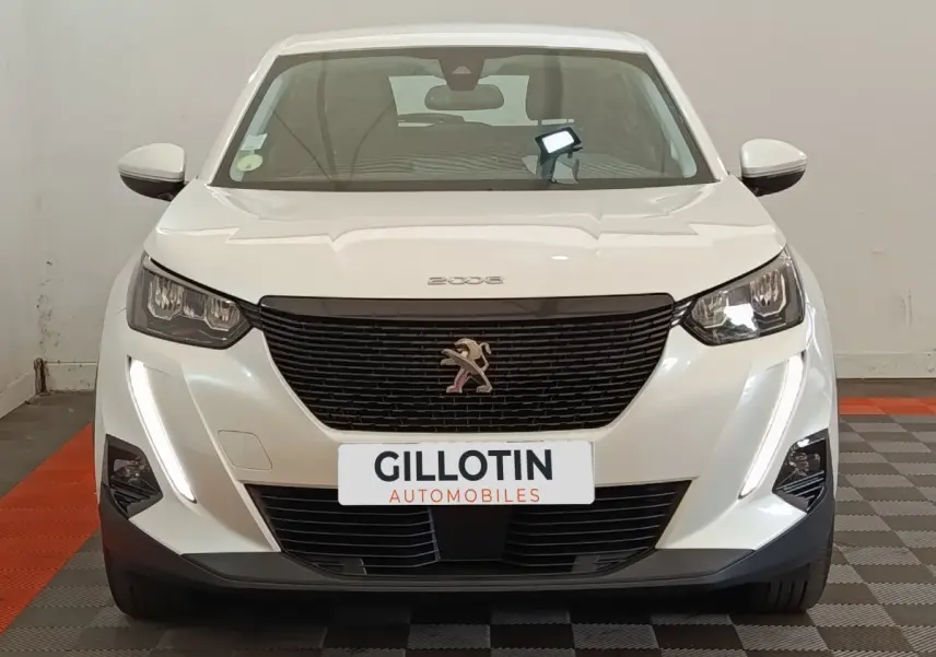 Peugeot 2008 blanc vue de face, avec calandre noire et feux LED diurnes verticaux allumés.
