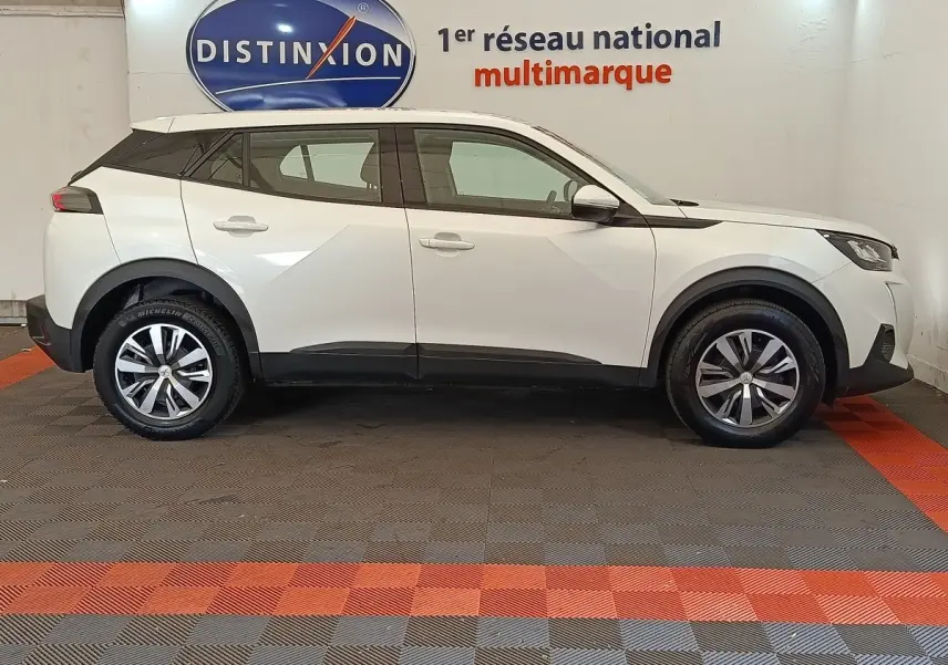 Peugeot 2008 blanc vue de profil côté gauche, avec jantes alliage et détails noirs contrastants.