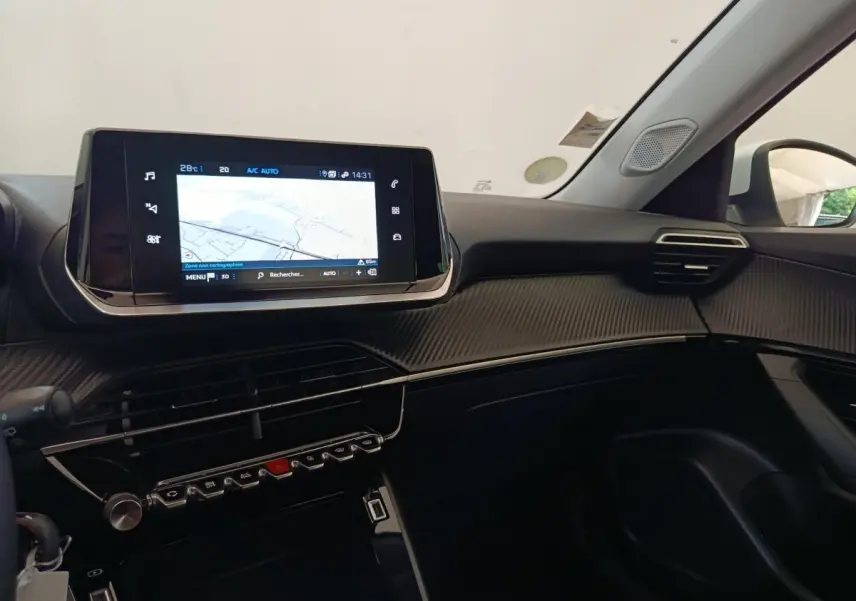 Tableau de bord intérieur du Peugeot 2008 blanc 2021, vue côté passager avec écran tactile de navigation allumé.