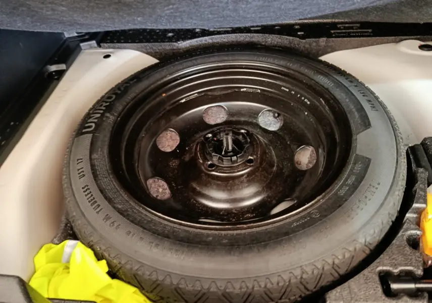 Gros plan sur la roue de secours noire dans le coffre blanc d’un Peugeot 2008 BlueHDi 130 de 2021.