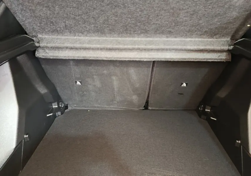 Coffre ouvert de Peugeot 2008 blanc, vue intérieure montrant la banquette arrière rabattue et le plancher plat.