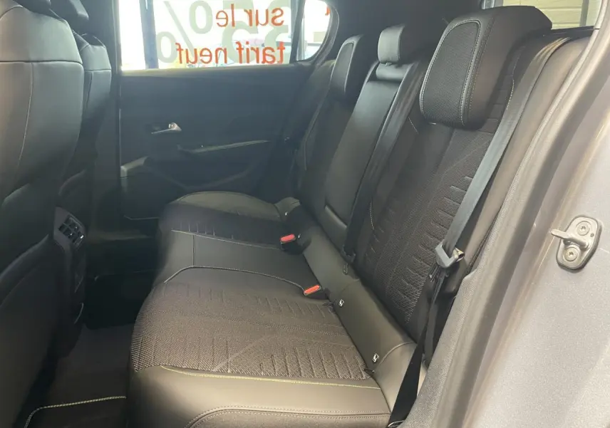 Vue côté droit de la banquette arrière noire de la Peugeot 308 GT 2026 avec surpiqûres vert Adamite et ceinture de sécurité.