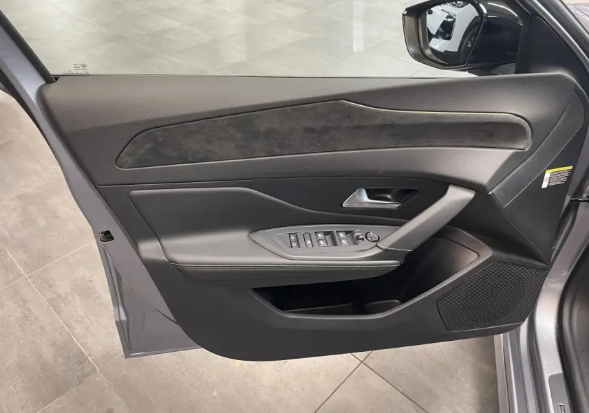 Vue intérieure de la porte avant gauche gris Artense avec surpiqûres vert Adamite et insert Alcantara sur Peugeot 308 2026.