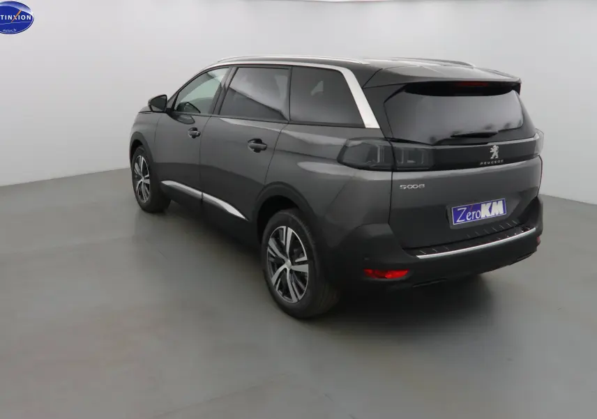 Peugeot 5008 gris platinium métal en vue 3/4 arrière droit, avec feux arrière fumés et jantes alliage bicolores.