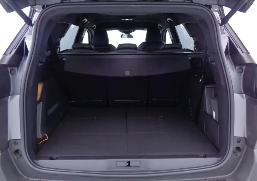 Coffre ouvert vu de l'arrière d'un Peugeot 5008 gris platinium métal, montrant un espace de chargement spacieux et modulable.