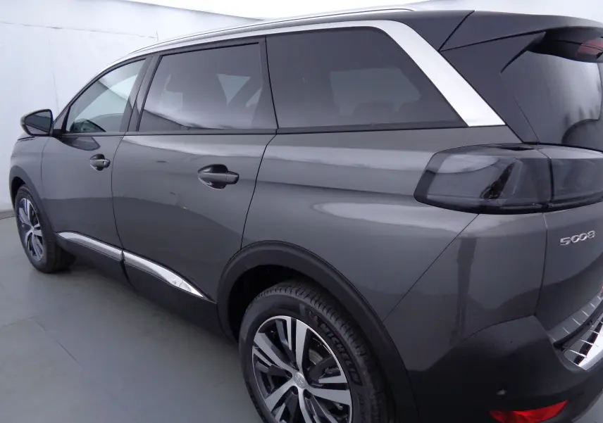 Vue 3/4 arrière côté droit du Peugeot 5008 gris platinium métallisé avec vitres teintées et jantes alliage bicolores.