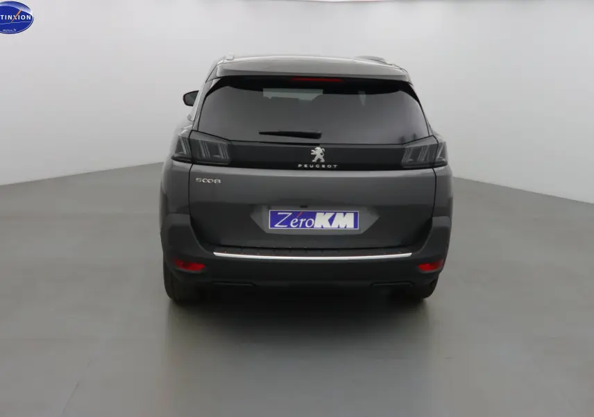 Vue arrière d'un Peugeot 5008 gris platinium métal avec feux LED et hayon fermé dans un studio blanc.
