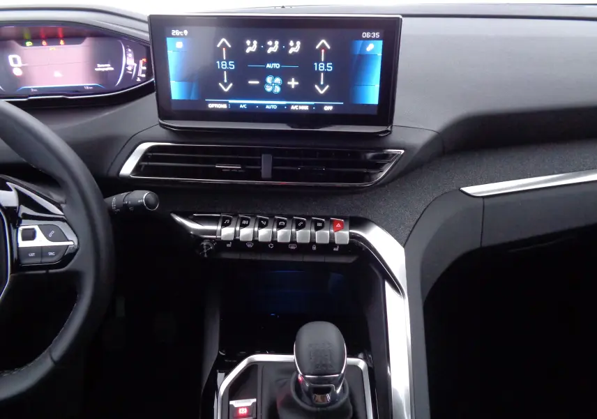 Vue intérieure du tableau de bord et console centrale du Peugeot 5008 gris platinium, mettant en valeur l'écran tactile et la boîte manuelle.