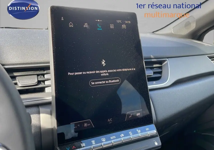 Écran tactile central du tableau de bord du Renault Captur 2025, intérieur gris avec commandes climatisation visibles.