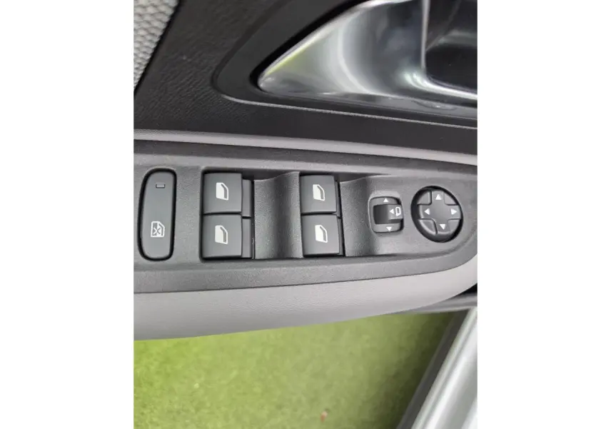 Gros plan sur les commandes de lève-vitres et réglages des rétroviseurs côté conducteur d'une Citroën C4 blanche.