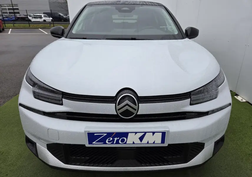 Vue avant d'une Citroën C4 blanche Okenite avec toit noir et logo double chevron bien visible.
