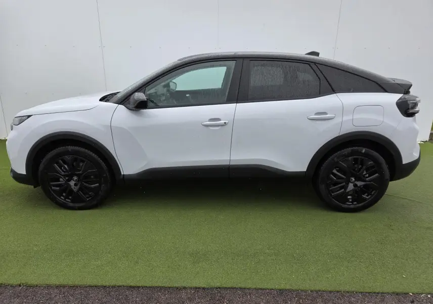 Profil côté gauche d'une Citroën C4 blanche avec toit noir et jantes alliage noires sur fond vert.