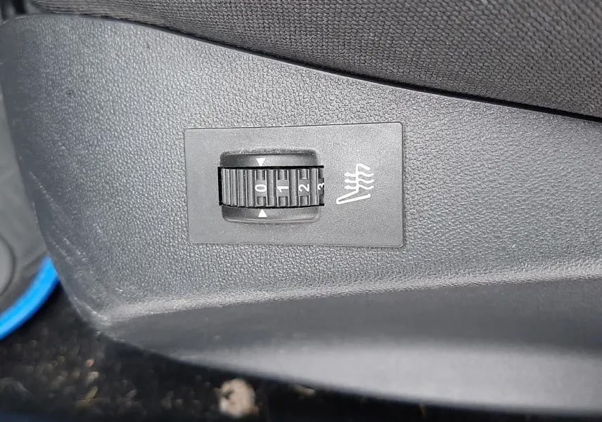 Réglage du chauffage de siège en gros plan sur la console intérieure noire d'une Peugeot 208 Bleu Nuit 2019