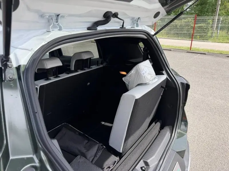 Vue arrière du coffre ouvert du Citroën C3 Aircross Vert Montana avec sièges arrière rabattables et 7 places visibles.