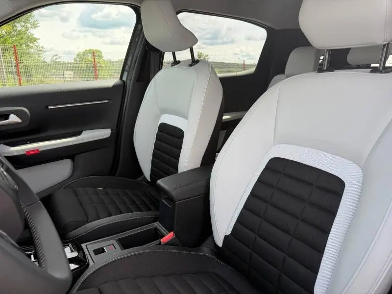 Vue intérieure côté avant gauche montrant les sièges bicolores noir et blanc du Citroën C3 Aircross 2026.
