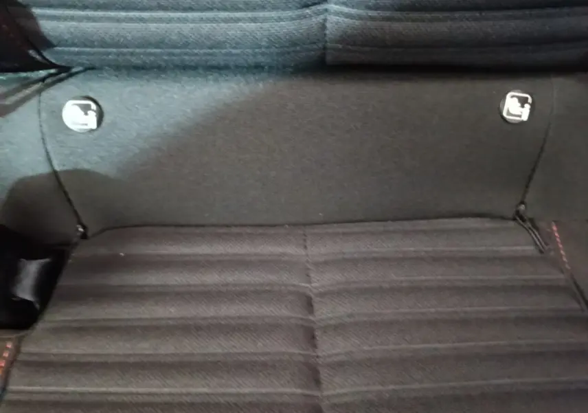 Gros plan sur la banquette arrière noire du Peugeot 208 2023, montrant les fixations Isofix de chaque côté.