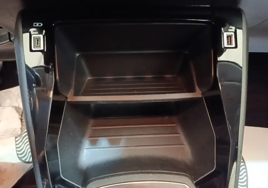 Vue rapprochée de la console centrale noire de la Peugeot 208 PureTech 100 S&S Active Pack avec ports USB visibles.