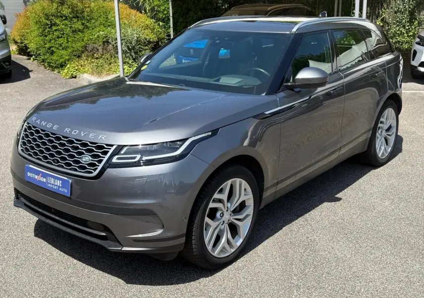 Vue 3/4 avant d'un Range Rover Velar gris métallisé avec calandre distinctive et jantes alliage argentées.