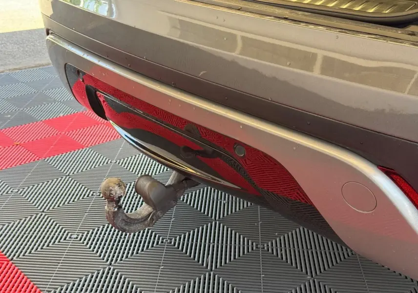 Gros plan sur l'attelage arrière du Range Rover Velar gris, soulignant le pare-chocs et le feu arrière droit.