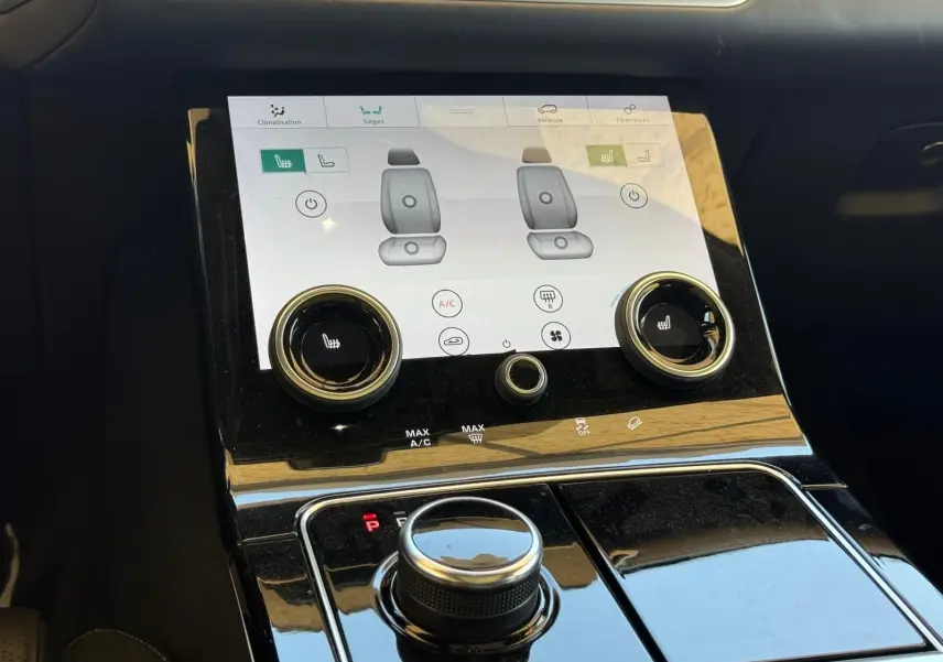 Gros plan sur la console centrale du Range Rover Velar 2019, écran tactile et commandes de climatisation visibles.