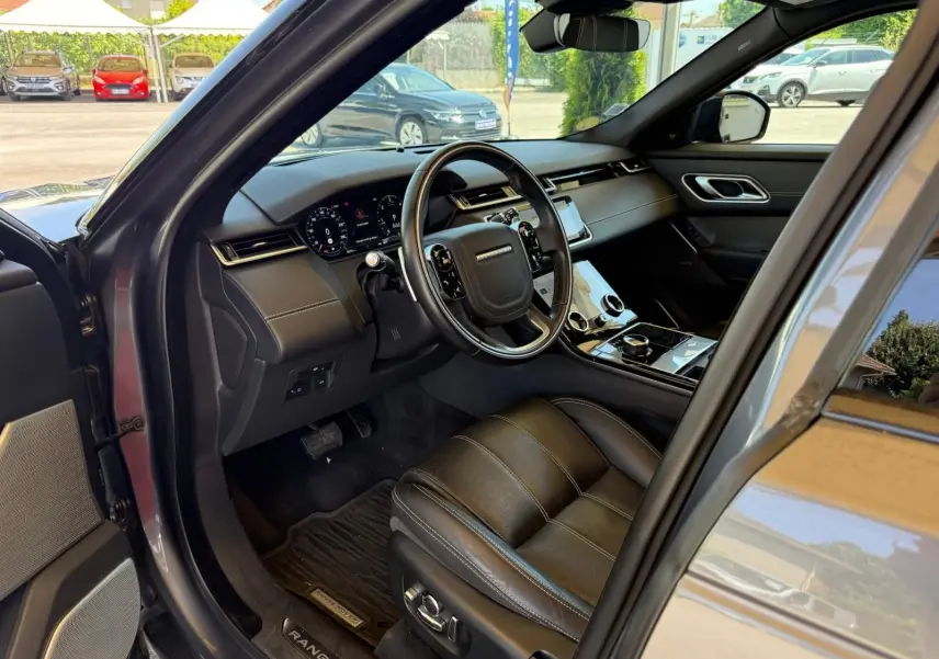 Intérieur côté conducteur du Range Rover Velar gris 2019, avec tableau de bord numérique et sellerie cuir Windsor.