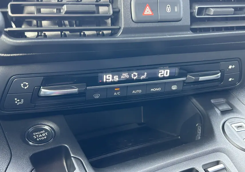 Vue rapprochée de la console centrale du Peugeot Partner Fourgon 2025, affichant la climatisation automatique et le bouton start/stop.