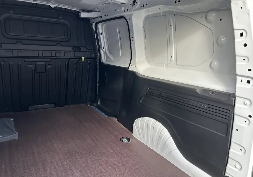 Vue intérieure côté droit du fourgon blanc Peugeot Partner avec plancher bois et parois noires.