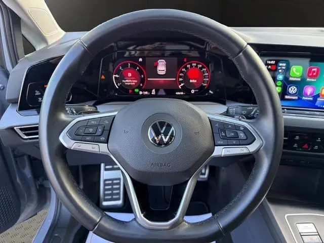 Vue frontale du volant cuir multifonction de la Volkswagen Golf VIII gris lunaire avec tableau de bord numérique et écran tactile.