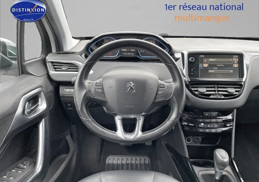 Vue intérieure centrée sur le volant cuir noir et le tableau de bord avec écran tactile du Peugeot 2008 blanc nacré 2015.