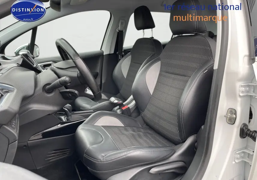 Vue intérieure côté conducteur d'une Peugeot 2008 blanc nacré, sièges en cuir noir avec surpiqûres blanches.