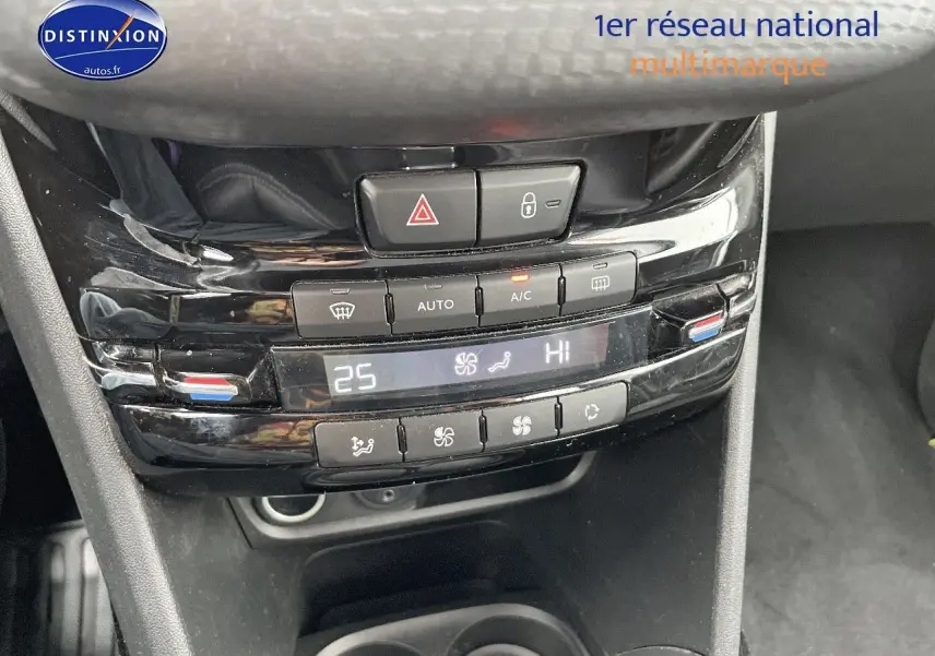 Gros plan sur la console centrale noire brillante de la Peugeot 2008 blanche, affichant la climatisation automatique à 25°C.