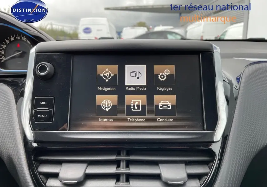 Écran tactile central du tableau de bord du Peugeot 2008 blanc nacré, affichant les menus navigation et média.