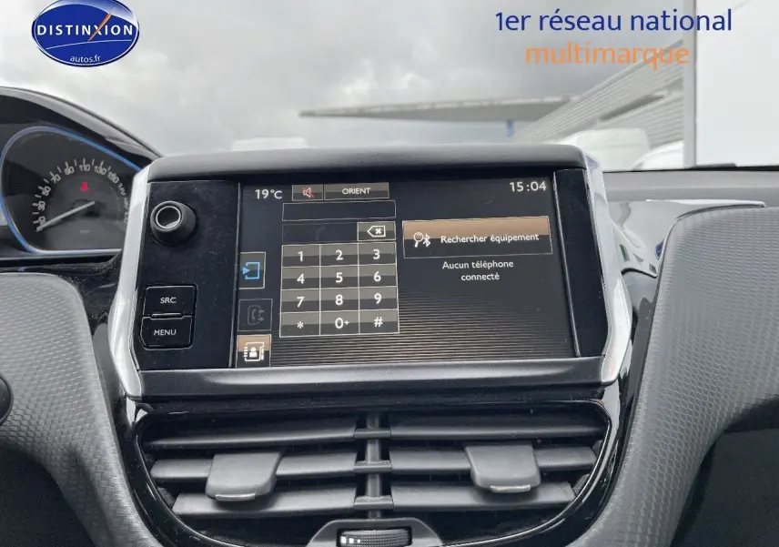 Écran tactile central du tableau de bord de la Peugeot 2008 blanc nacré, avec commandes et affichage du téléphone.