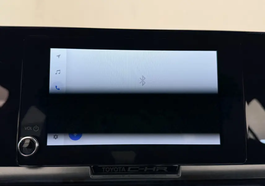 Écran tactile central allumé avec interface Bluetooth sur tableau de bord noir du Toyota C-HR blanc 2024.