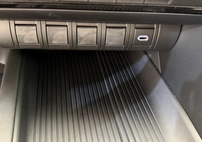 Gros plan sur la console centrale noire du Toyota C-HR 1.8 Hybride 140 Dynamic avec port USB-C visible.