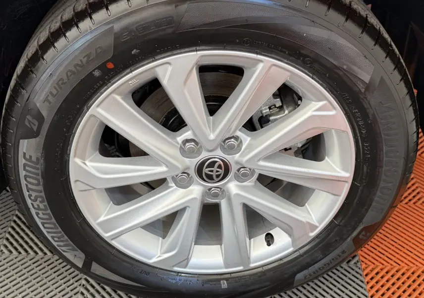 Gros plan sur la jante argentée et le pneu Bridgestone du Toyota C-HR blanc 2024 hybride.