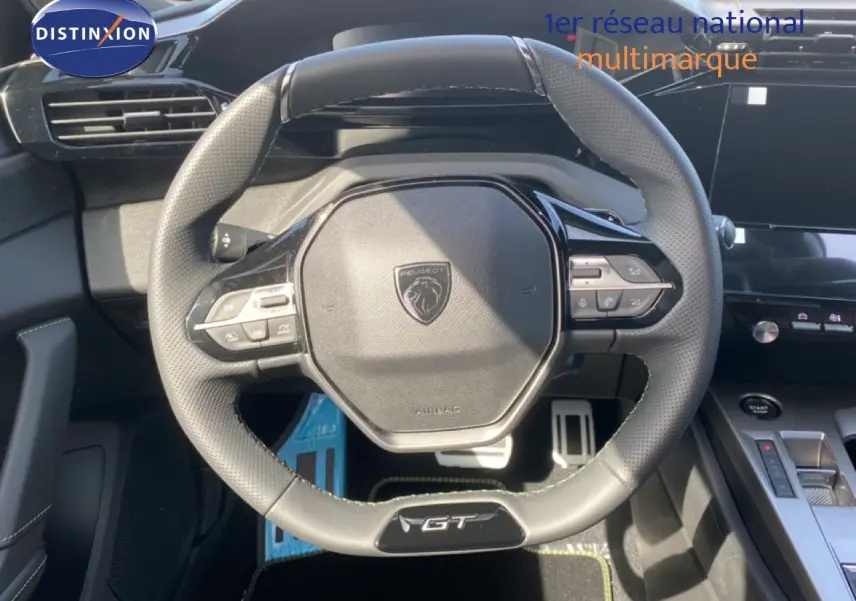 Volant cuir noir GT de la Peugeot 308 Hybrid 2026 vu de face avec commandes intégrées et tableau de bord moderne.