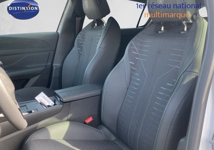 Vue intérieure côté droit montrant les sièges avant en tissu et cuir noir avec logo Peugeot brodé sur les appuie-têtes.