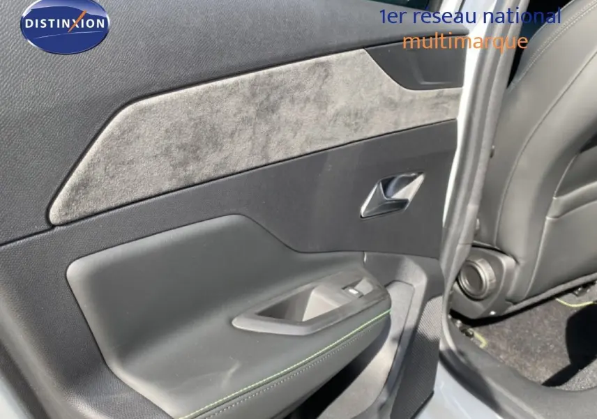 Vue rapprochée de la porte arrière droite de la Peugeot 308 blanche, avec garniture noire et insert tissu gris.