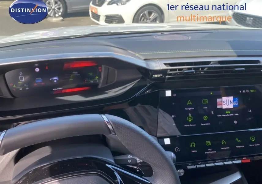 Vue intérieure du tableau de bord et volant de la Peugeot 308 hybride 2026 avec écran digital et finition noire brillante.