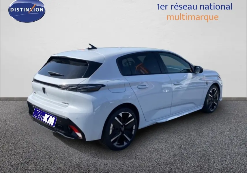 Peugeot 308 blanc Okenite métal en 3/4 arrière droit, jantes noires et vitres teintées visibles.