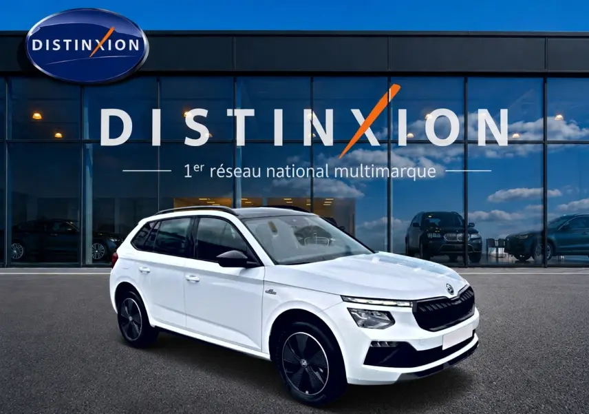 SKODA KAMIQ Monte Carlo blanc nacré en 3/4 avant droit, avec jantes noires et toit panoramique visible.