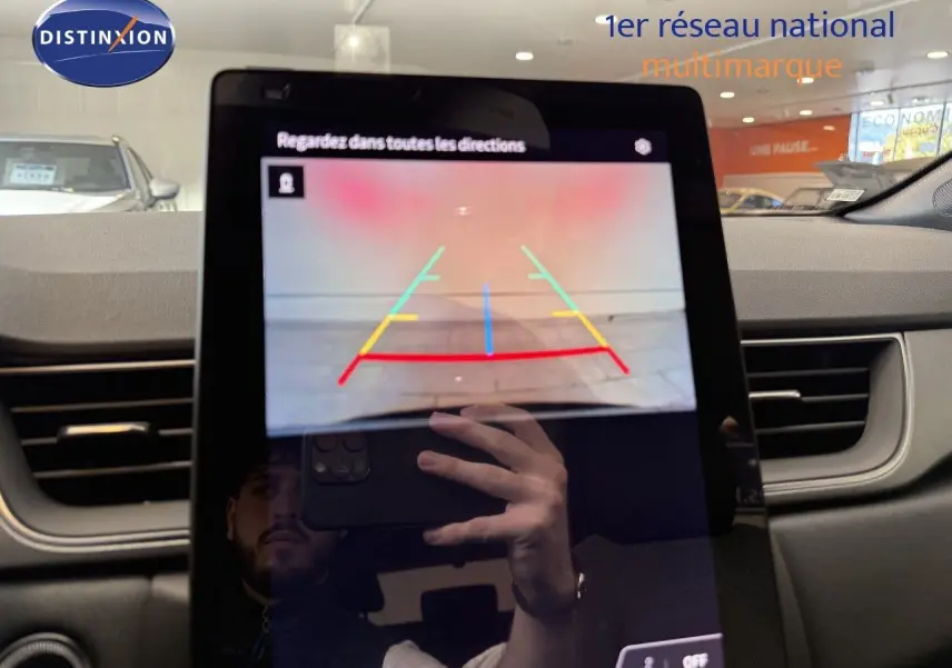 Vue intérieure centrée sur l'écran tactile affichant la caméra de recul du Renault Captur gris cassiopée métal.